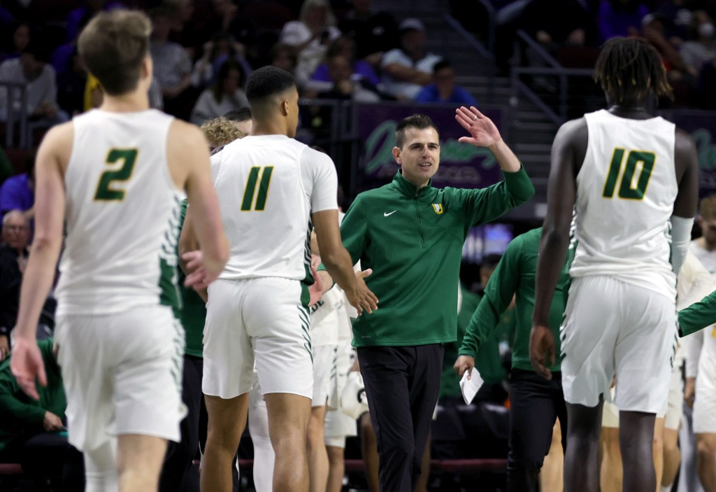 San Francisco Dons head coach Todd Golden high-fives players during a timeout in their game against the Brigham Young Cougars during the West Coast Conference basketball tournament quarterfinals at the Orleans Arena on March 5, 2022 in Las Vegas.