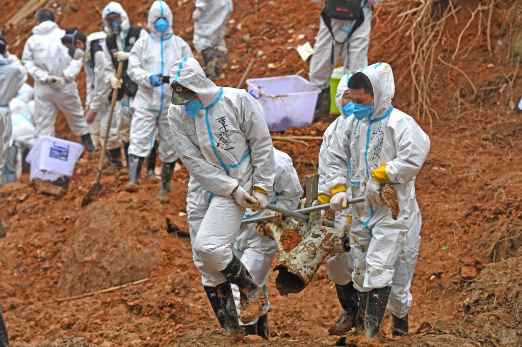 Workers carry plane crash pieces