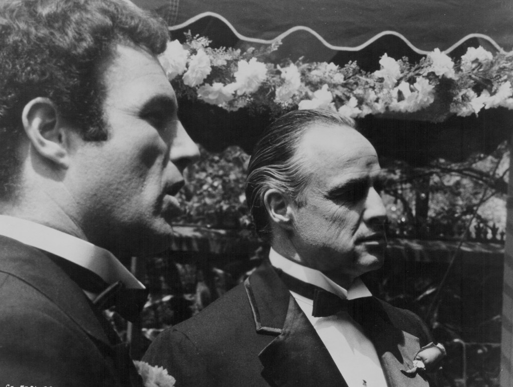 Photo of James Caan and Marlon Brando in a scene from Connie's wedding in "The Godfather." They're both wearing tuxedos.