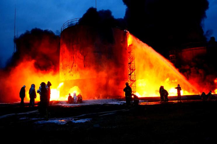 Rescuers work at a site of fuel storage facilities hit by cruise missiles in Lviv, in this handout picture released March 27, 2022.