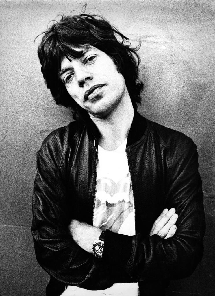 Mick Jagger poses with his head cocked in a black and white photo.