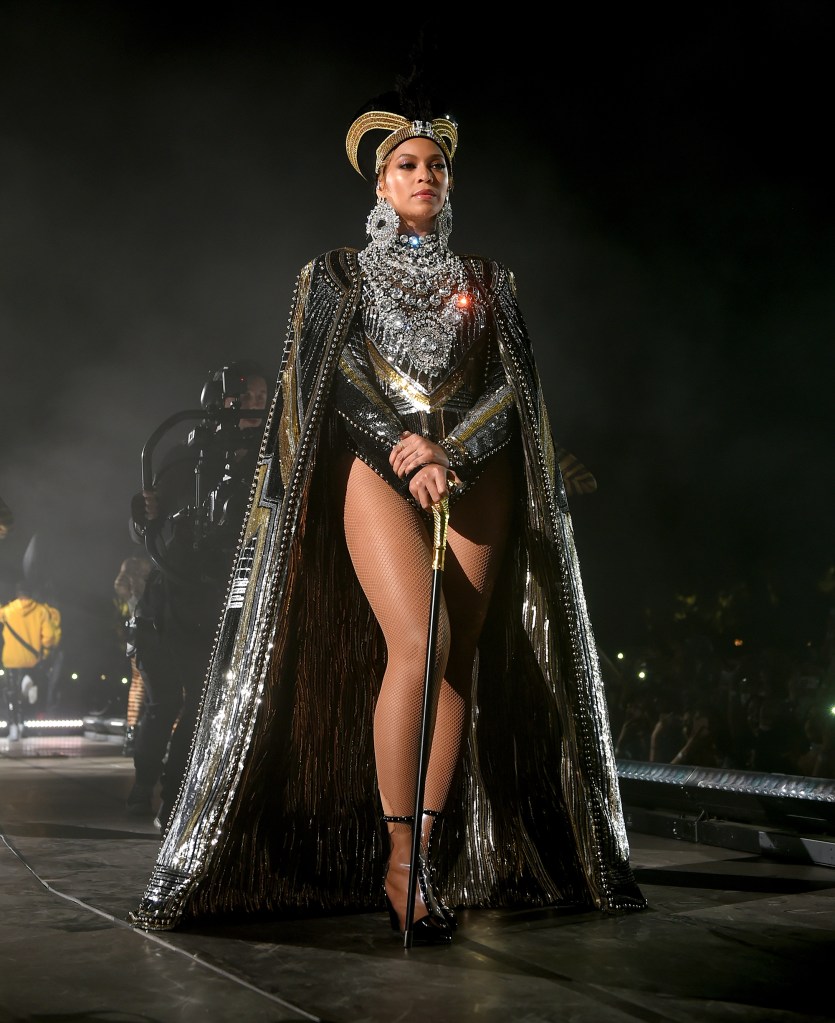 Beyone on stage in a gold crown, cape and cane.