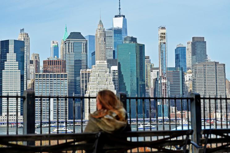 Woman sits on park bench.