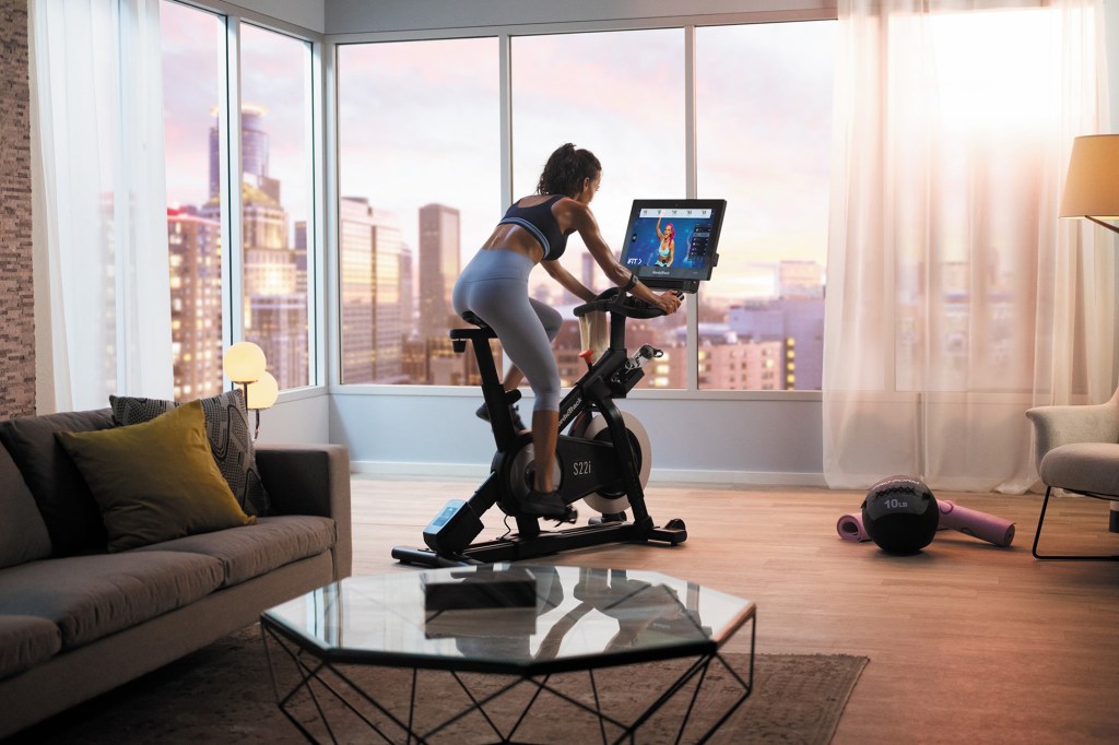 A woman using a NordicTrack bike in a livingroom.