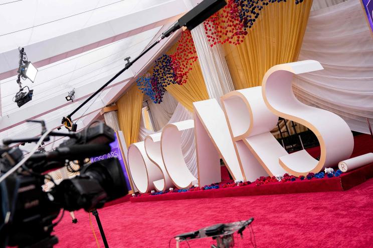 A television camera sits in front of an Oscars sign on the red carpet near the Dolby Theater.