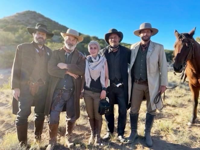 Halyna Hutchins (center) along with Alec Baldwin (center left) and the cast of Rust.