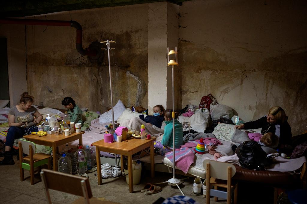 Sick children and women with their newborn babies stand at a basement used as a bomb shelter at the Okhmadet children's hospital on March 1, 2022.