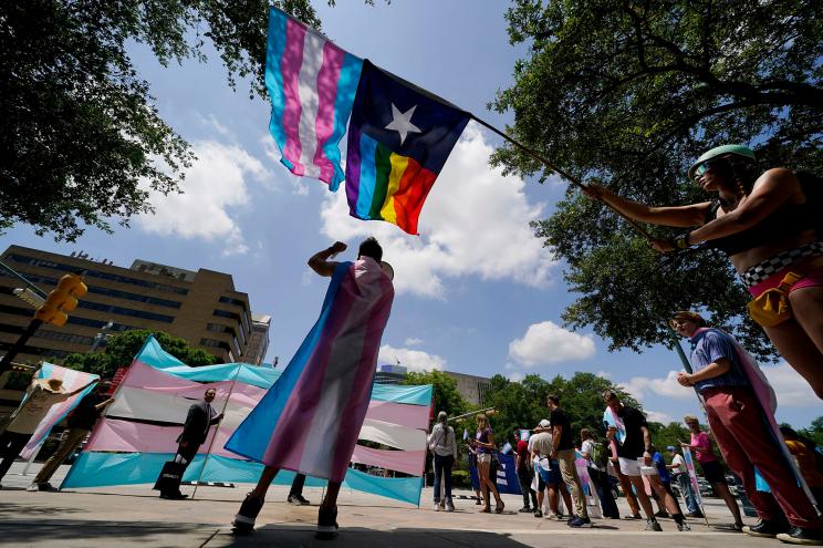 Demonstrators fly an LGBTQ flag near the Texas State Capitol in Austin.