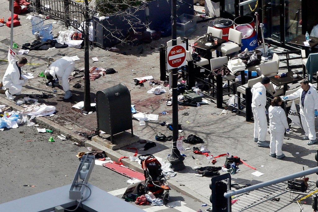 Investigators examine the scene of the second bombing outside the Forum Restaurant on Boylston Street near the finish line of the 2013 Boston Marathon