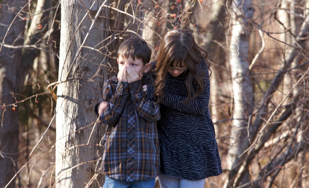 Young children wait outside Sandy Hook Elementary School after a shooting in Newtown, Connecticut, December 14, 2012.