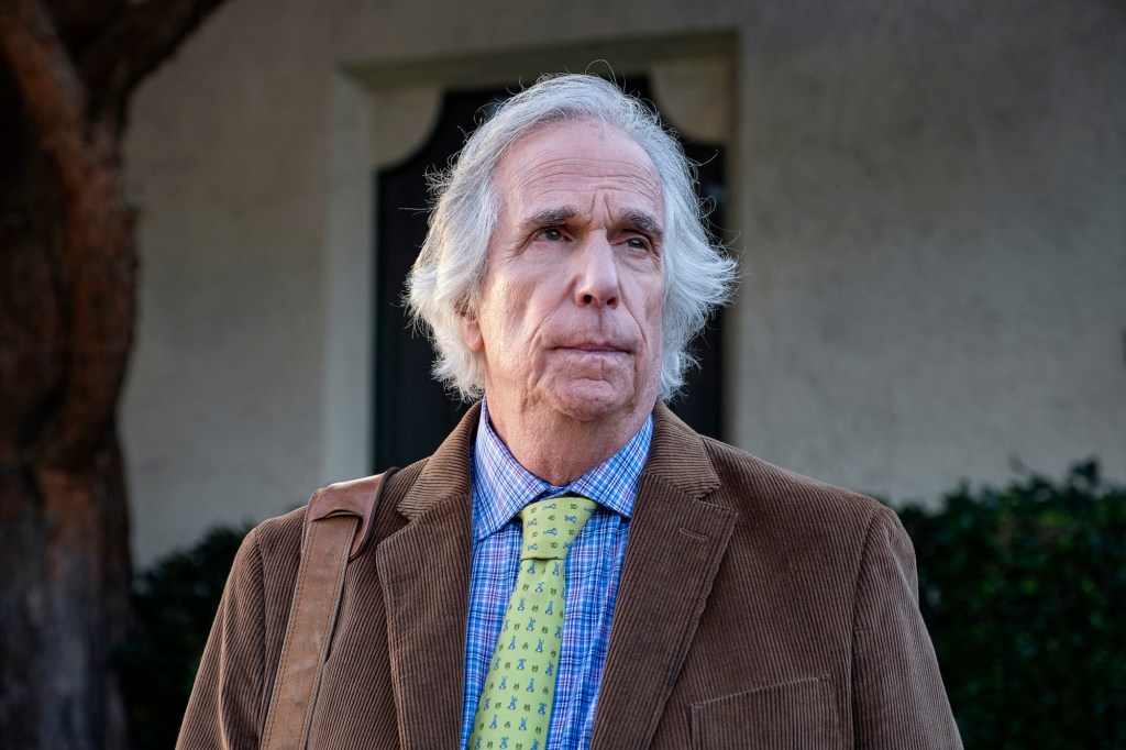 Henry Winkler in his Emmy-winning role as Gene Cousineau in Season 3 of "Barry" on HBO. He's wearing a brown corduroy jacket with a green tie and blue shirt and is pursing his lips and looking serious.