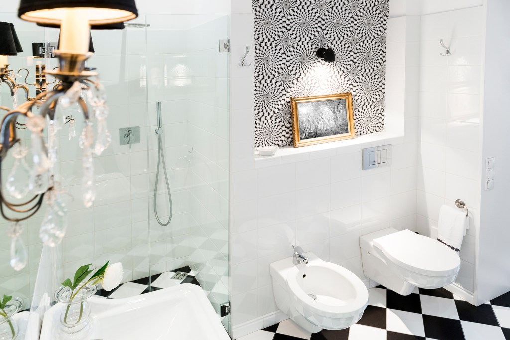 Black and white bathroom with bidets.