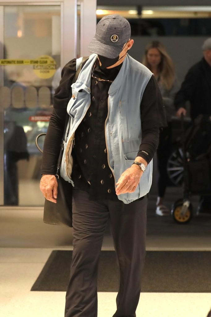 Bill Murray is seen with his head down while wearing a black mask.