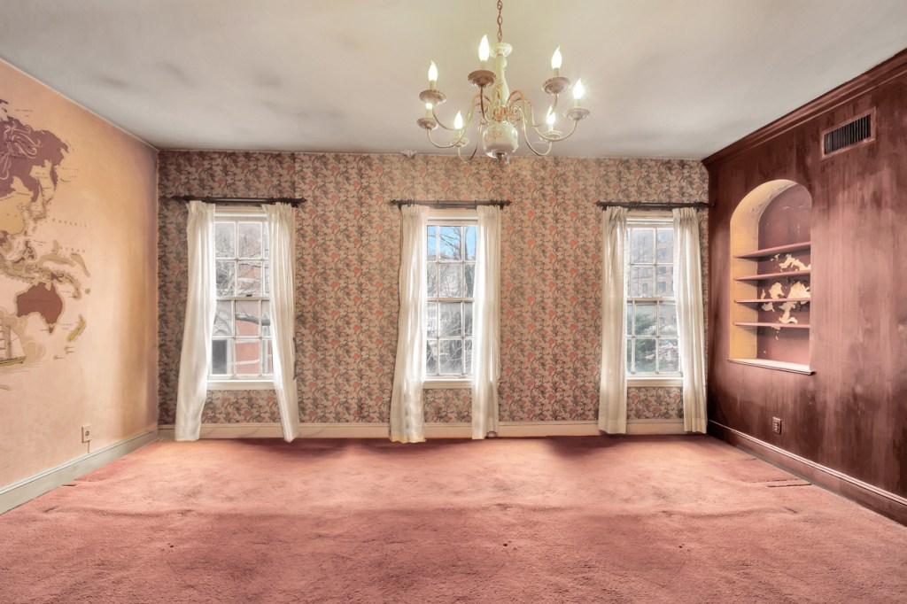 A room with geographer art and red velvet carpeting.