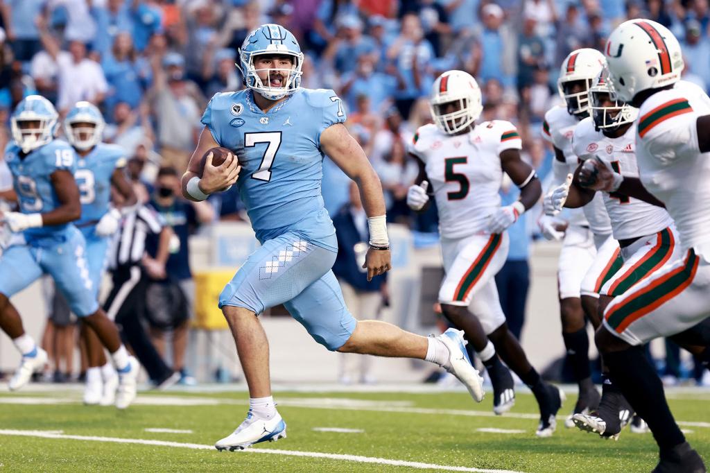 Sam Howell #7 of the North Carolina Tar Heels breaks free for a touchdown against the Miami Hurricanes during their game at Kenan Memorial Stadium on October 16, 2021 in Chapel Hill, North Carolina. North Carolina won 45-42.