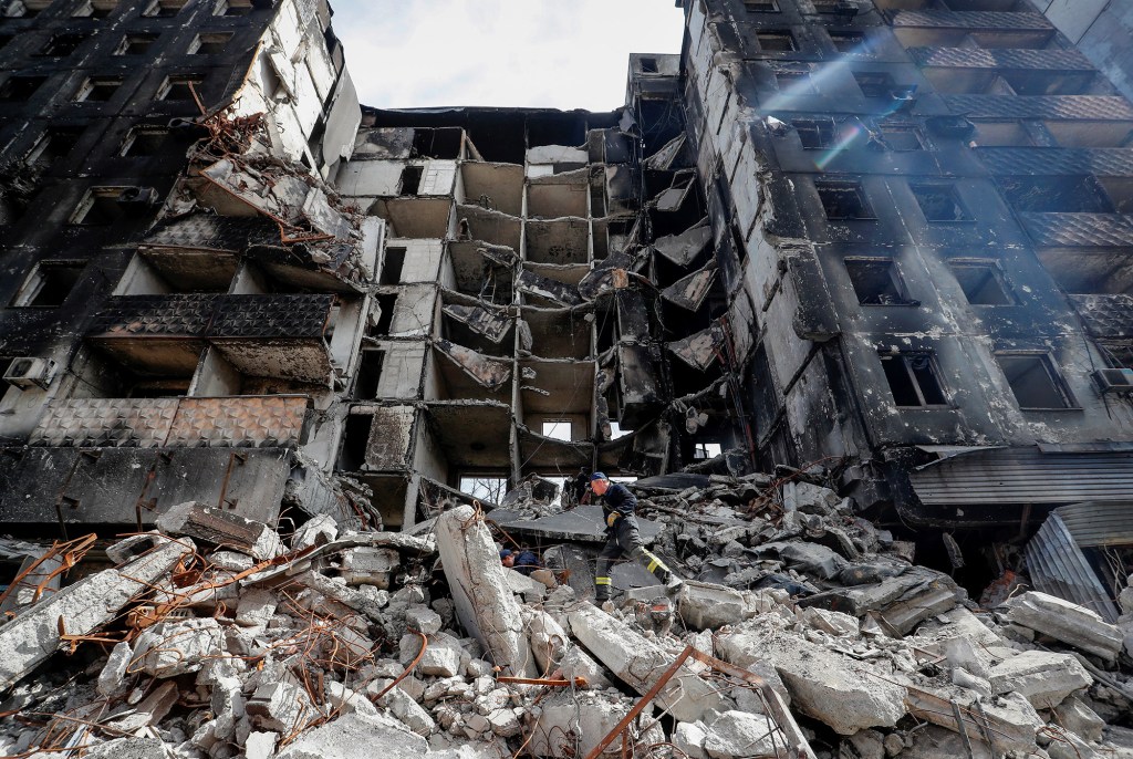 Emergency workers remove debris of a building destroyed in Mariupol.