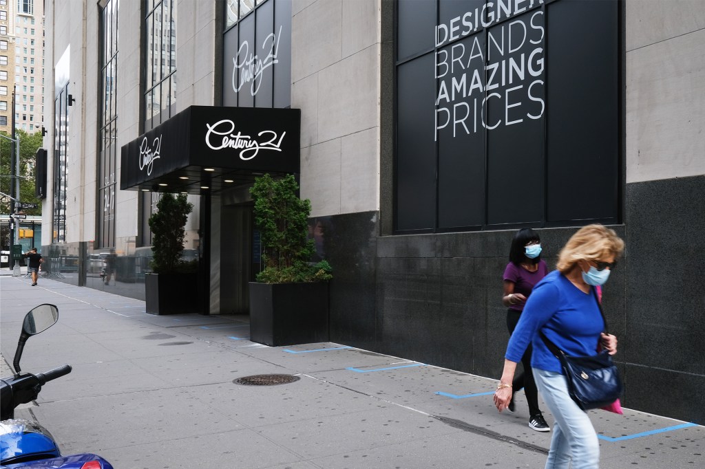 A shuttered Century 21 store with blacked out store windows.