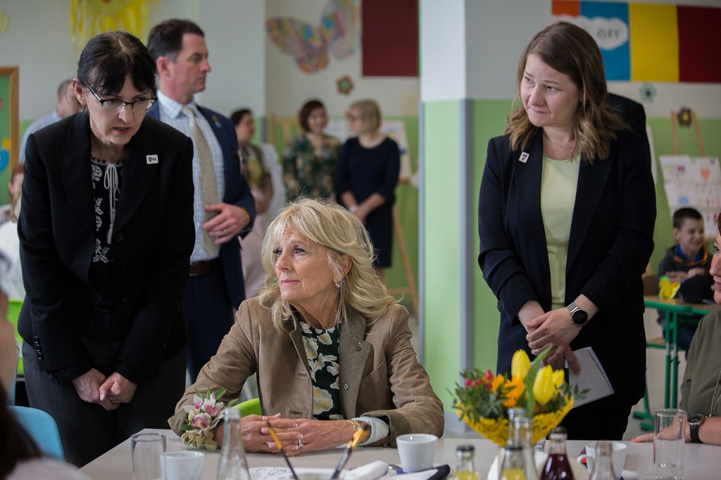 First Lady Jill Biden is shown seated at a table in a classroom in Kosice, Slovakia.