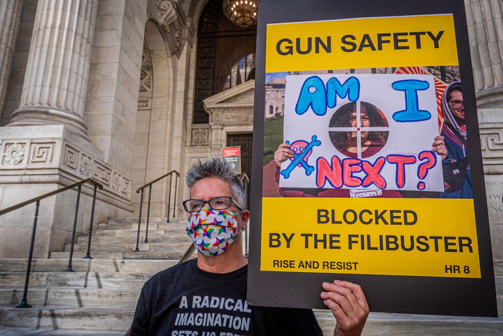 Participant seen holding a sign depicting an issue blocked by filibuster at the protest.