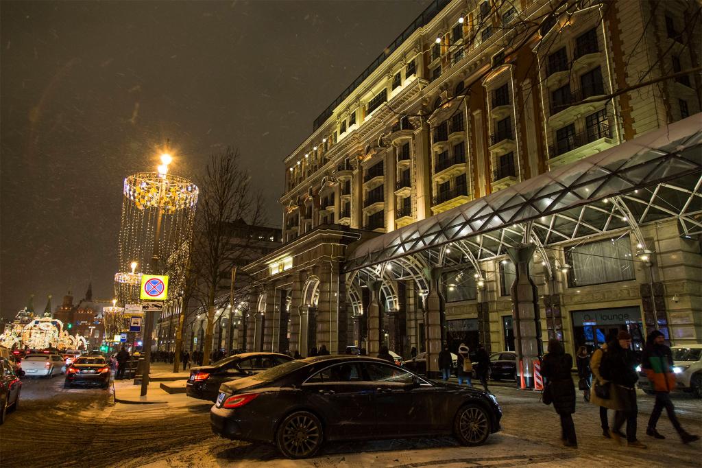 In this photo taken on Monday, Feb. 13, 2017, people walk past the Ritz-Carlton hotel, right, with Red Square behind in the background left, in Moscow, Russia.