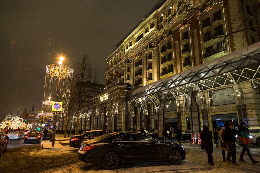 In this photo taken on Monday, Feb. 13, 2017, people walk past the Ritz-Carlton hotel, right, with Red Square behind in the background left, in Moscow, Russia. 