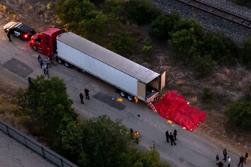 Police investigate the trailer where 53 bodies were eventually discovered dead.