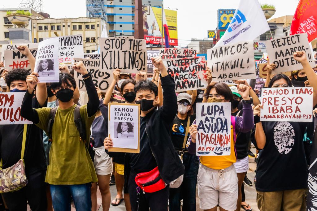 Protesters hold placards during a demonstration against Ferdinand Marcos Jr. in Plaza Miranda.