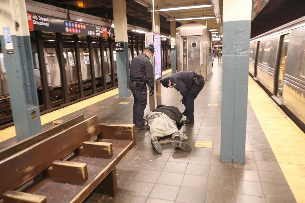 Officers removing a homeless (possibly medically ill) man from the 'R' train line platform.