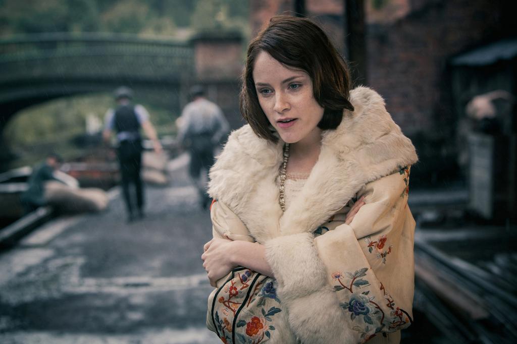 Sophie Rundle wearing a fur coat standing outside.