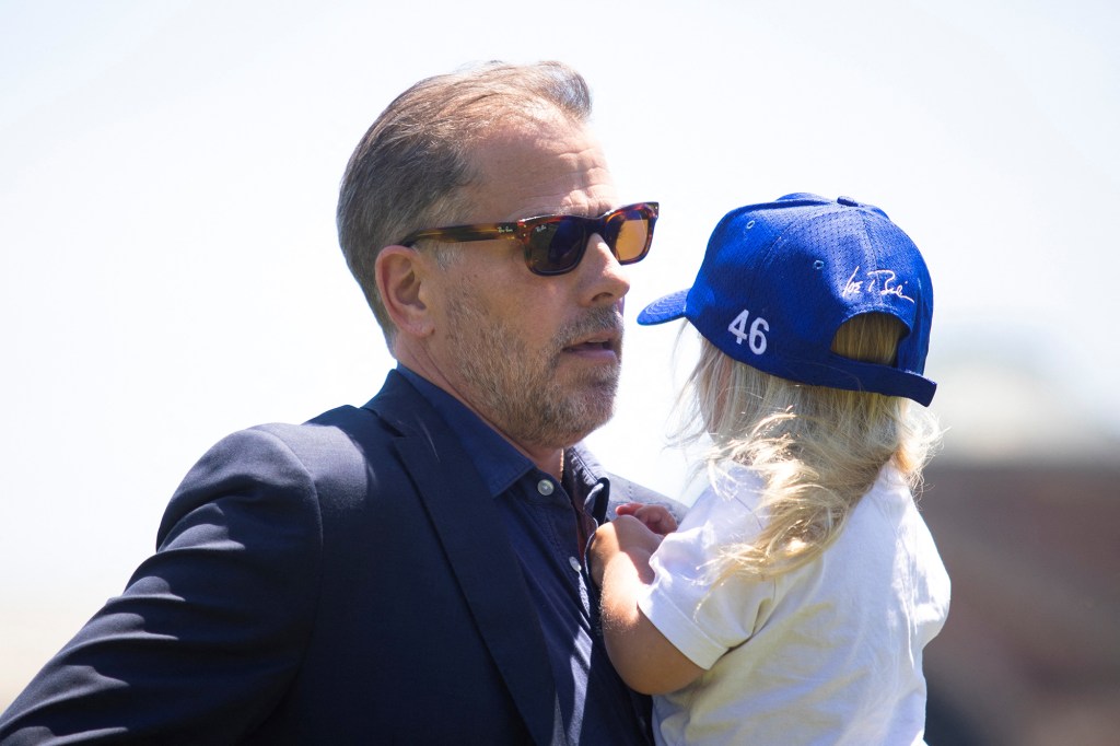 Hunter Biden, son of U.S. President Joe Biden, carries his son Beau, after exiting Marine One with the president and first lady at Fort McNair in Washington, U.S., July 4, 2022. 