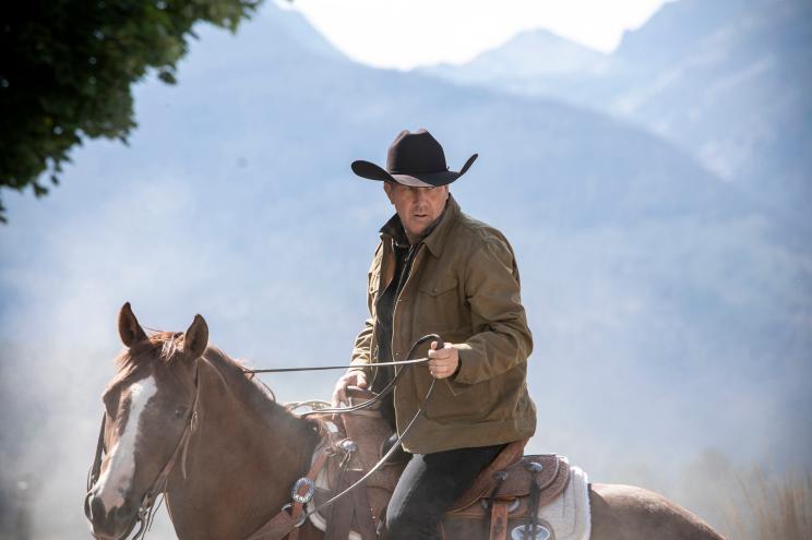 Cable series titan "Yellowstone," and series star Kevin Costner were snubbed by Emmy voters for the fourth consecutive year. Photo of Kevin Costner riding a horse and wearing a cowboy hat with mountains in the background.