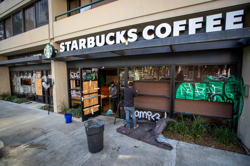 Starbucks Coffee workers clean up broken glass and replace several shattered windows when some Lakers vandals took to the streets and covered several blocks with graffiti, broke windows and vandalized businesses after their championship win the night before in LA.