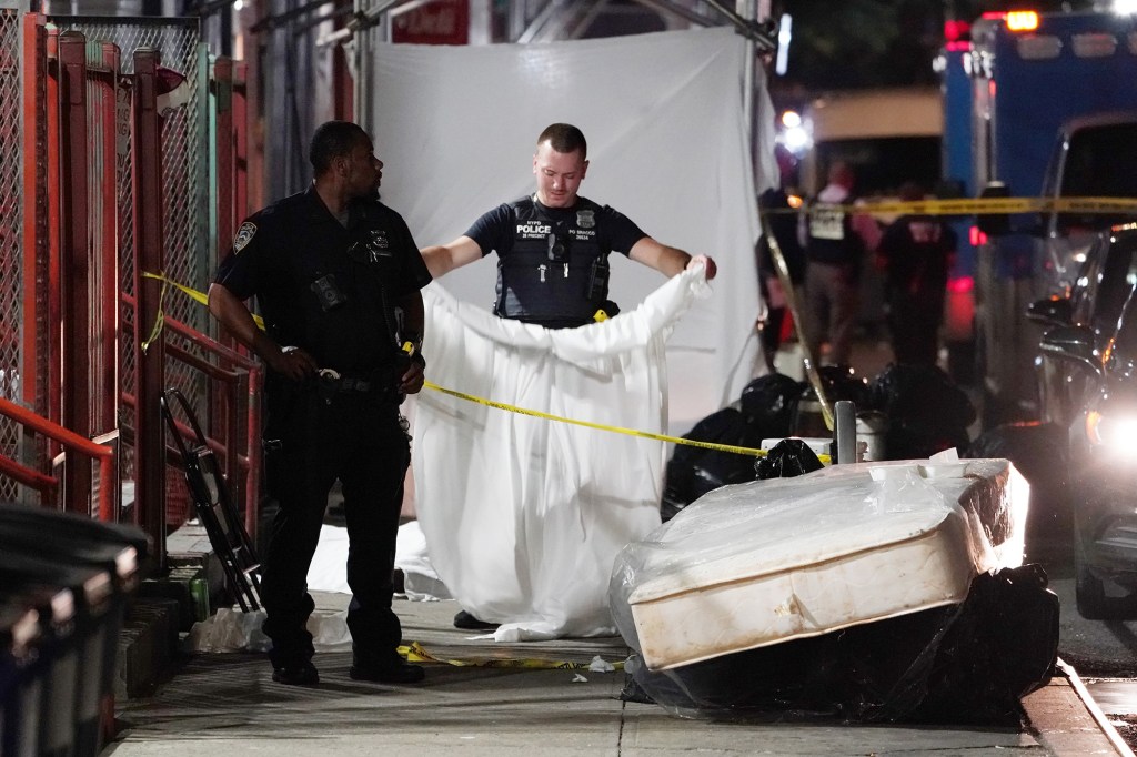 NYPD officers investigating the scene of a fatal shooting on West 124th Street in Manhattan on July 23, 2022.