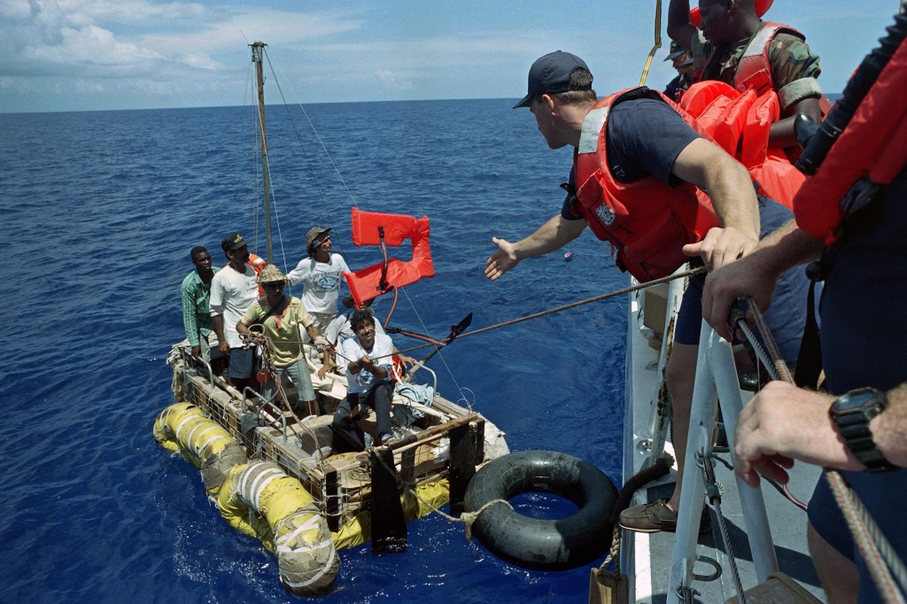 A crew's member of American coast guard cutter Maui throws a life jacket to a group of Cuban rafters on September 4, 1994.