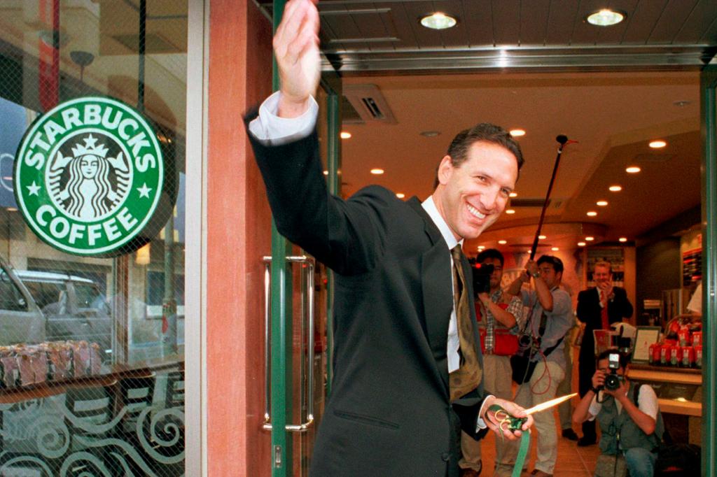 Howard Schultz, chairman and chief executive officer of Starbucks Coffee Co., waves after cutting the ribbon to inaugurate its store in Tokyo's Ginza shopping district.