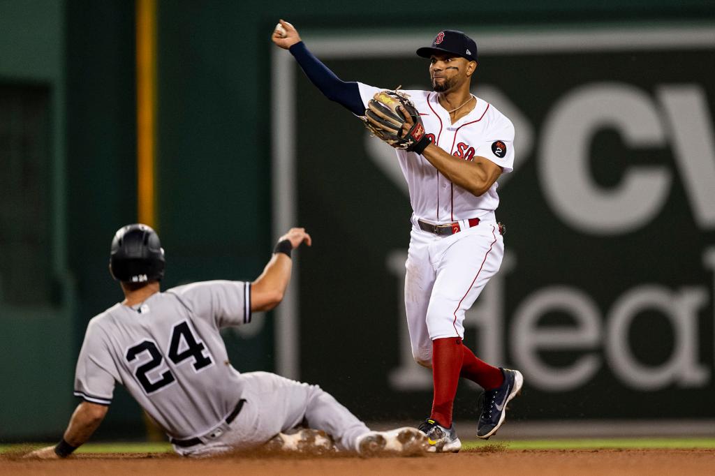 Xander Bogaerts #2 of the Boston Red Sox turns a double play over Matt Carpenter #24 of the New York Yankees during the fifth inning of a game on July 10, 2022 at Fenway Park in Boston, Massachusetts.