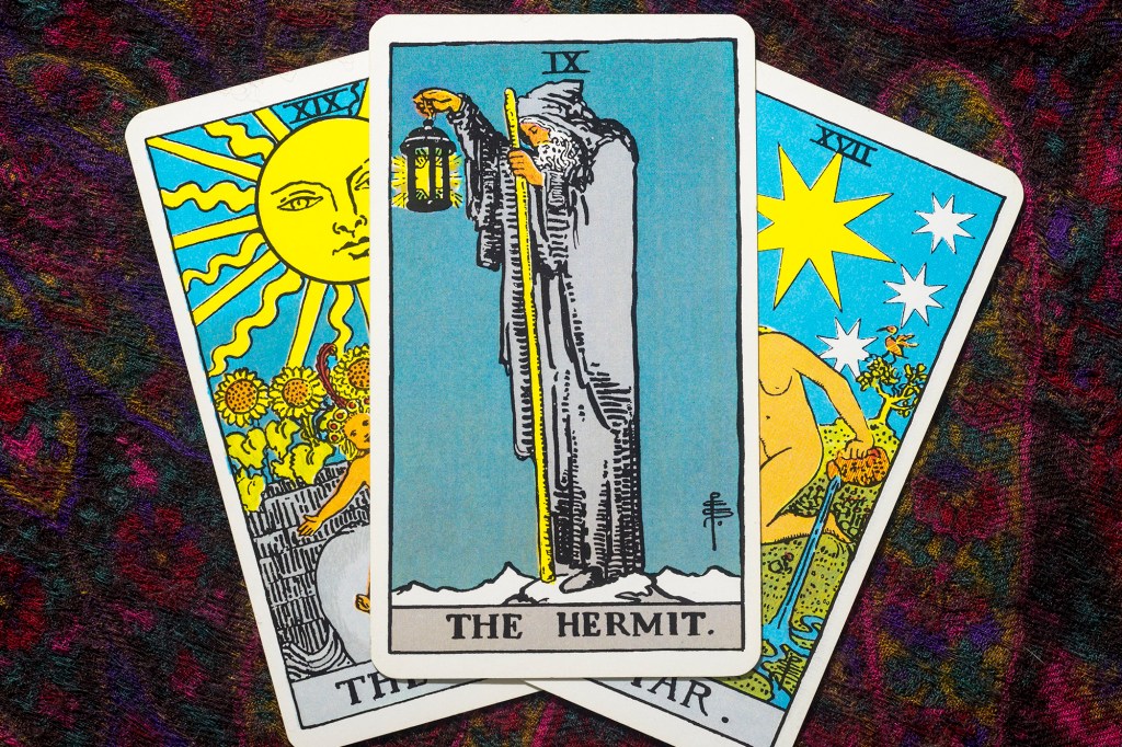 Illustrated tarot cards with "The Hermit" centered.