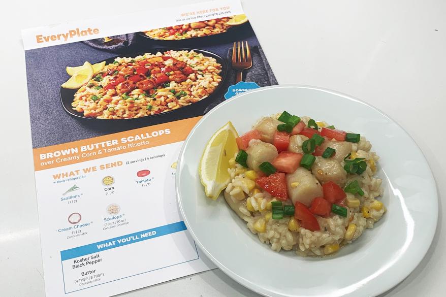 A plate of scallops on risotto next to a recipe for the meal