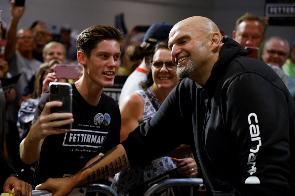 Fetterman takes a photograph with a supporter during a rally in Erie, Pa.