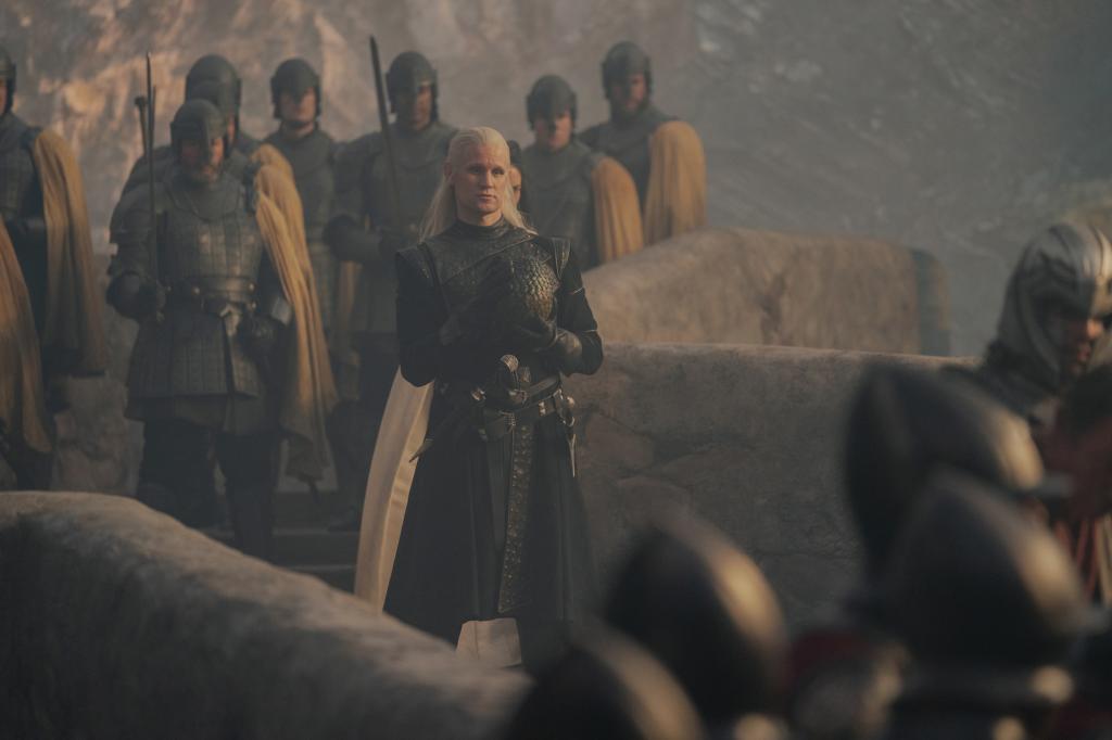 Matt Smith stands on a bridge in a bad silver wig.