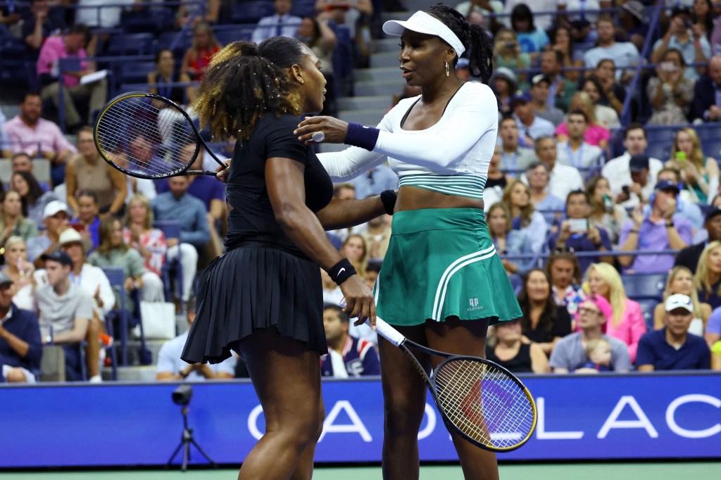 Venus and Serena Williams hug after their 7-6 (5), 6-4 U.S. Open doubles loss.