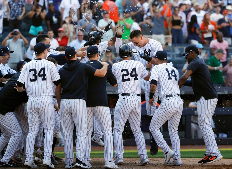 28 - His teammates celebrate at home plate after he connectrf on a walk off three run home run aginst the Houston Astros in the tenth inning, June 26.