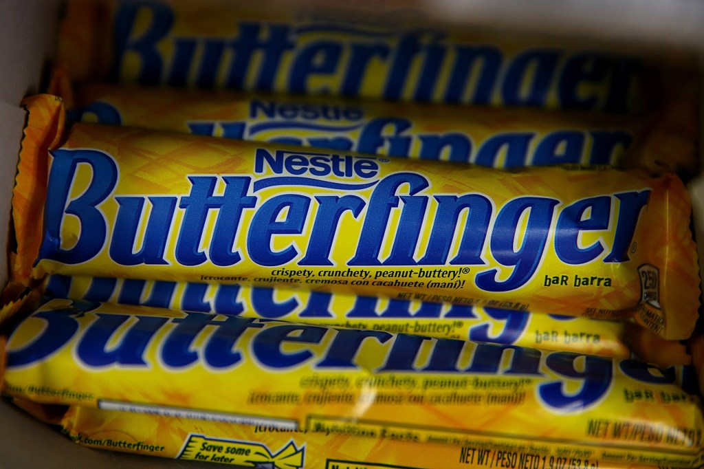 Nestle Butterfinger candy bars are displayed on a shelf. 