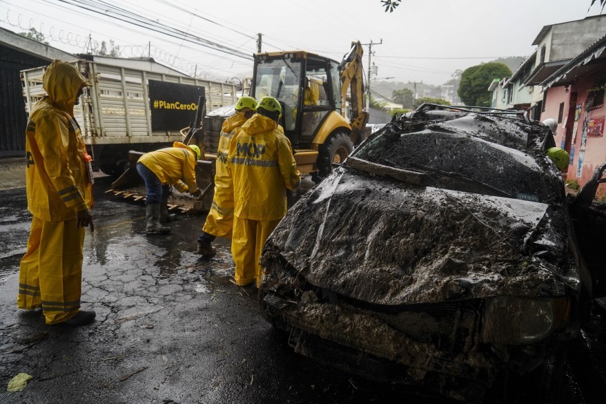 First responders work to pull out a car that was damaged by the powerful Hurricane Julia that left 28 dead across Central America.