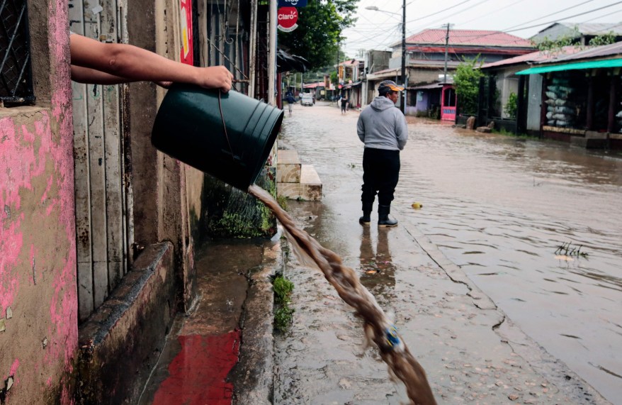 A resident buckets water out of his house after Hurricane Julia tore through the town of Bluefields in Nicaragua on Oct. 9, 2022.