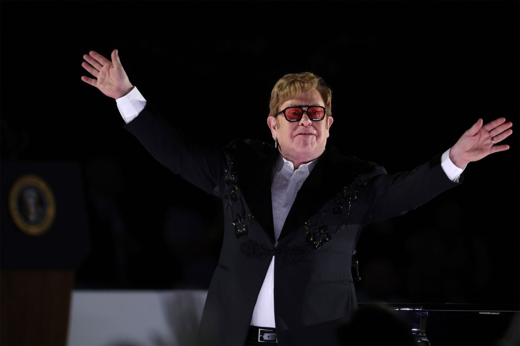 Singer Elton John gestures to the crowd.