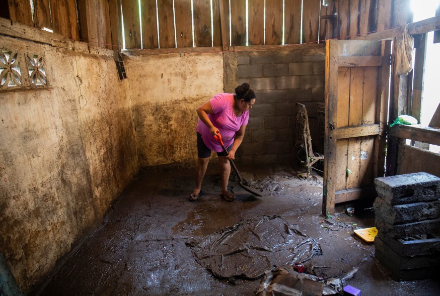 A woman cleans mud out of her home brought on by Hurricane Julia in La Cruz, Nicaragua, on Oct. 10, 2022.