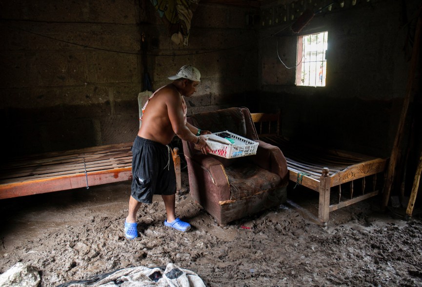 A man cleans mud from his home on Oct. 10, 2022, after Hurricane Julia caused mudslides in the area of La Cruz, Nicaragua.