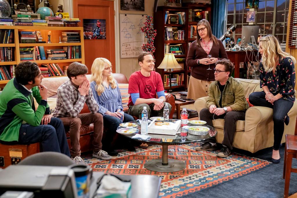 Kunal Nayyar, from left, Simon Helberg, Melissa Rauch, Jim Parsons, Mayim Bialik, Johnny Galecki and Kaley Cuoco on "The Big Bang Theory" sit on a couch in a living room.