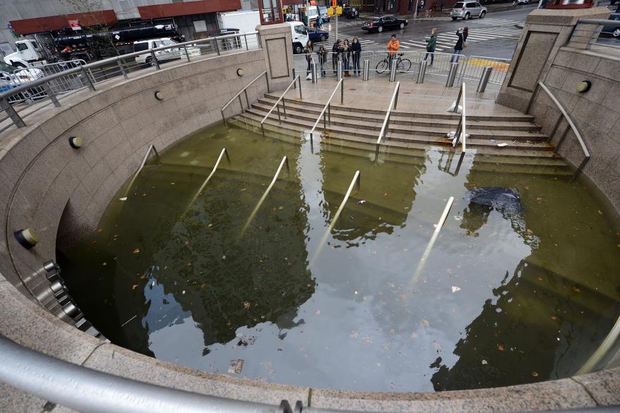 People take photos of water filling the entrance of The Plaza Shops in Battery Park the morning after Hurricane Sandy.